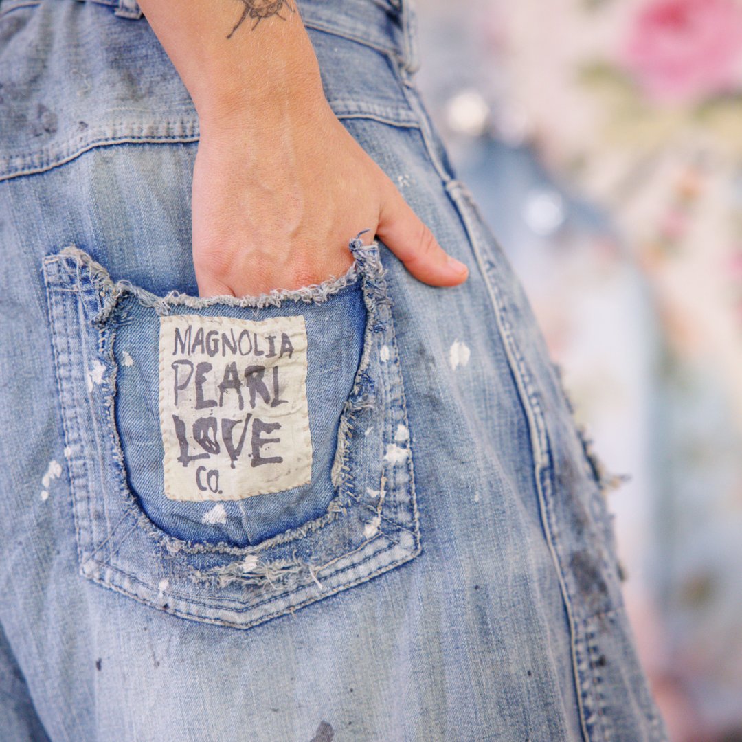 Magnolia Pearl artisan distressed denim jeans with whimsical vintage patch and hand detail