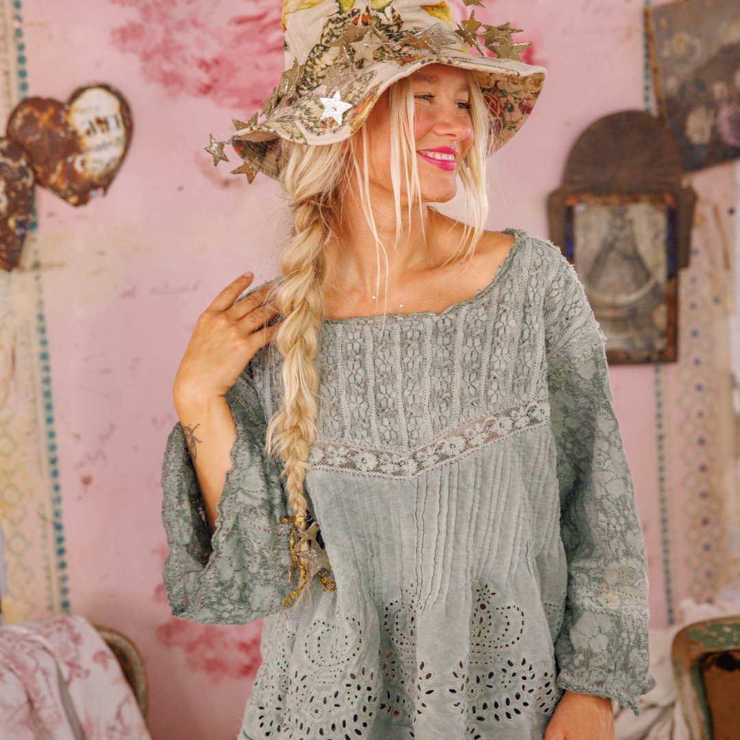 Woman in Magnolia Pearl artisan lace top and whimsical star hat, vintage shabby chic room