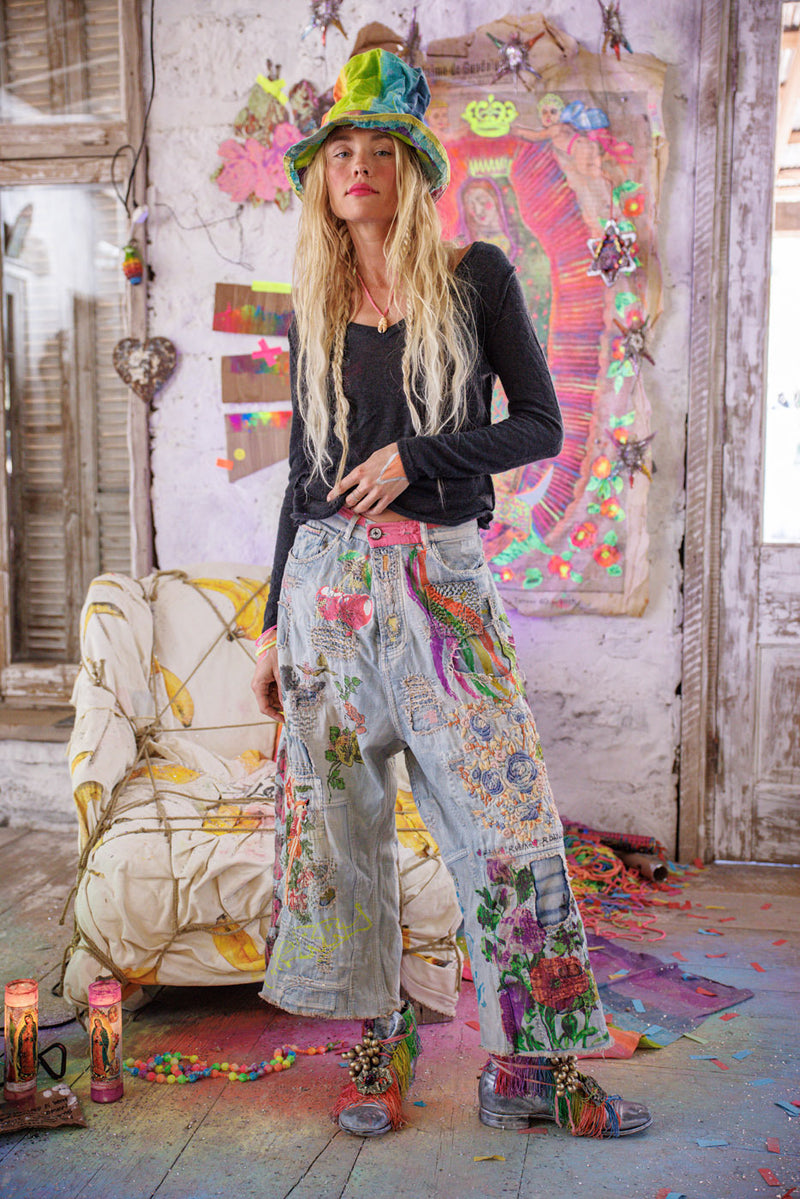 Woman in colorful patchwork jeans , cashmere top and tie-dye hat in bohemian art studio