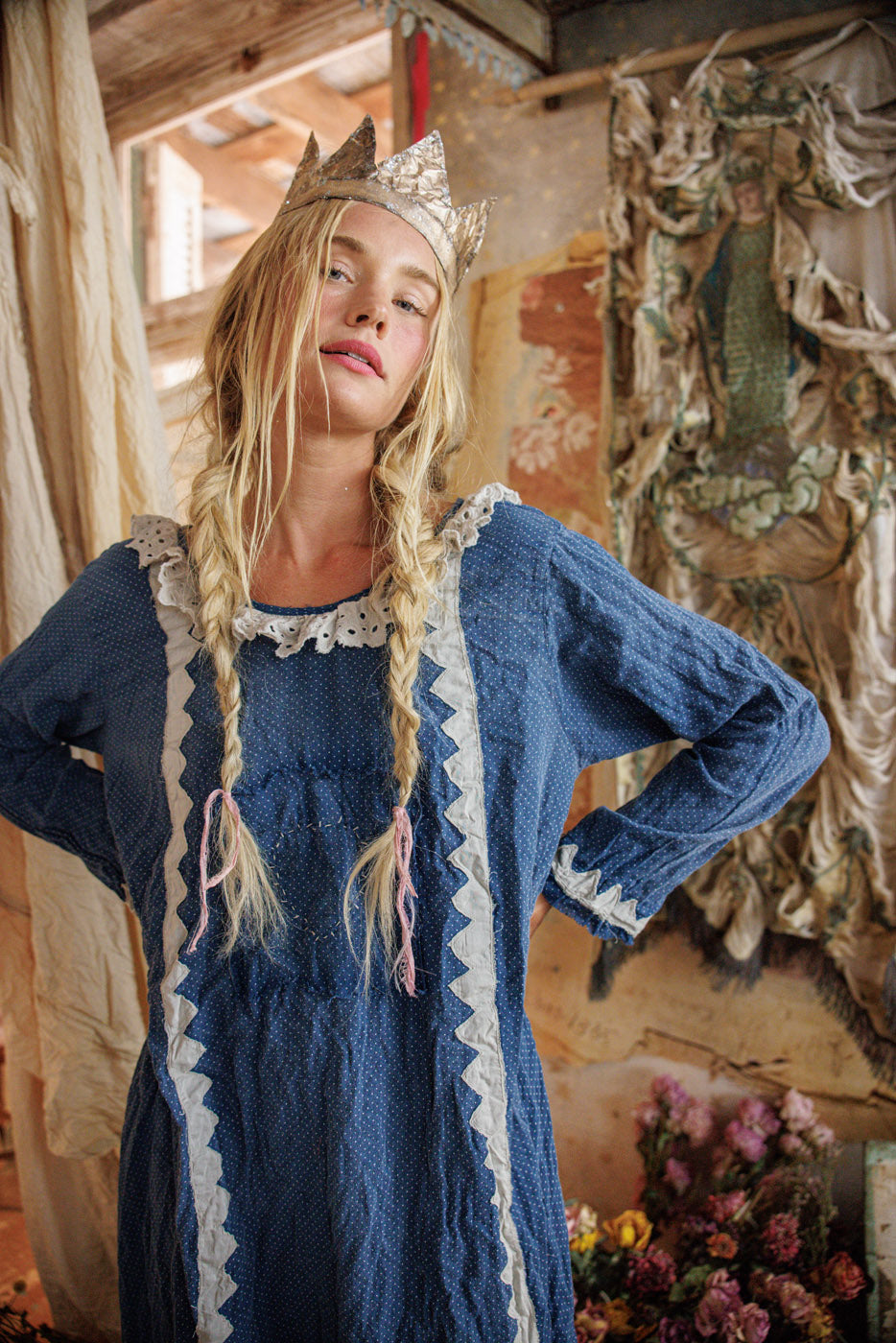 Woman in Magnolia Pearl artisan blue vintage dress, whimsical crown, rustic floral setting