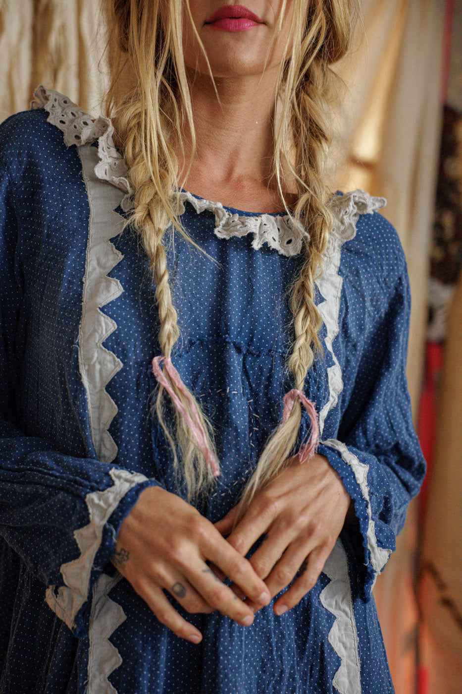 Woman in Magnolia Pearl artisan blue polka dot vintage dress with lace trim and braids