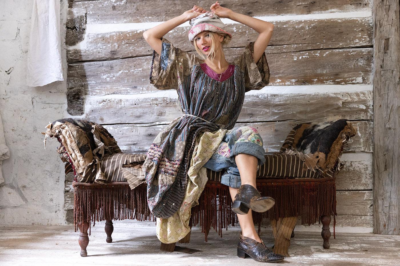 Woman in Magnolia Pearl artisan vintage dress, whimsical layered clothing on rustic bench