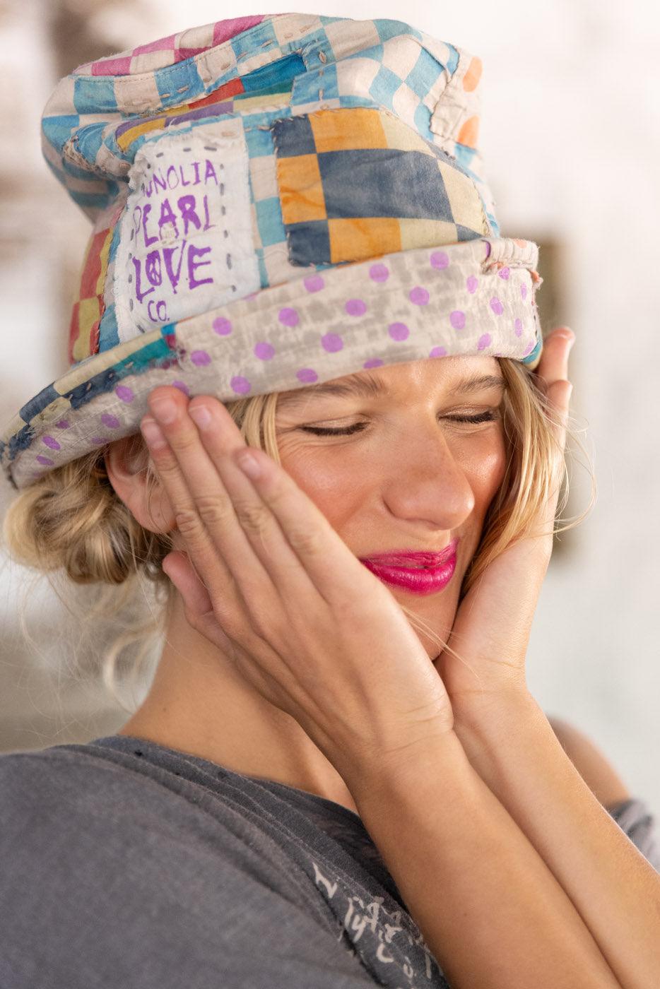 Smiling woman wearing Magnolia Pearl patchwork artisan hat with whimsical vintage style