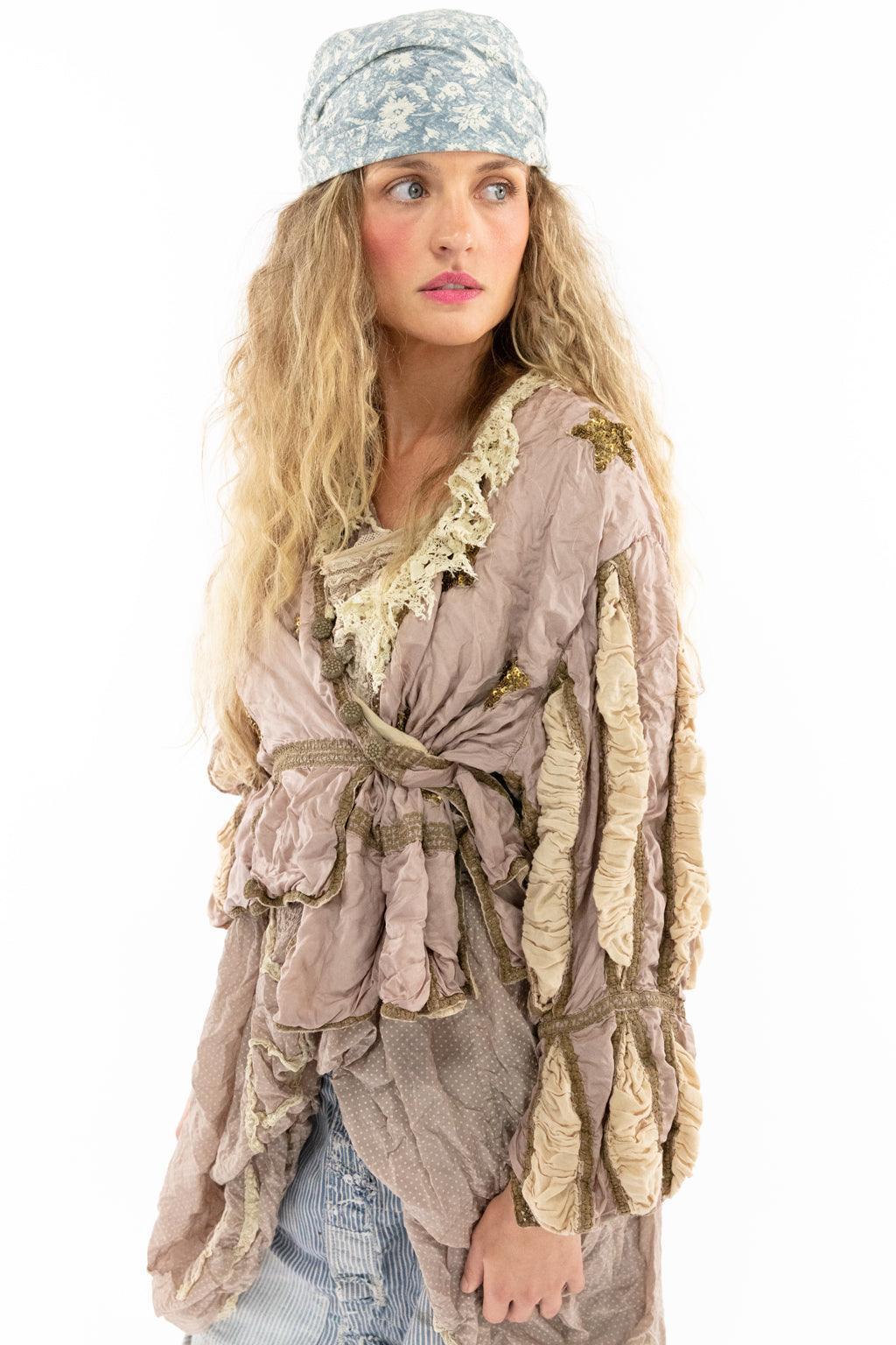 Woman in Magnolia Pearl lilac ruffled artisan jacket, vintage-style patched pants, and boots