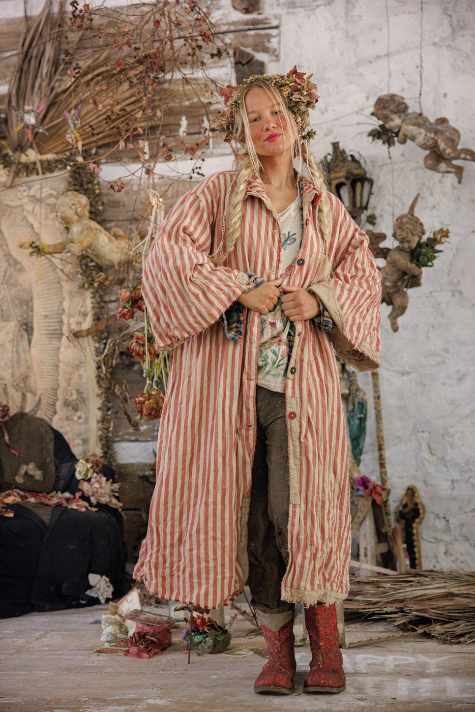 Woman in vintage Magnolia Pearl red striped artisan coat, floral crown, whimsical rustic setting