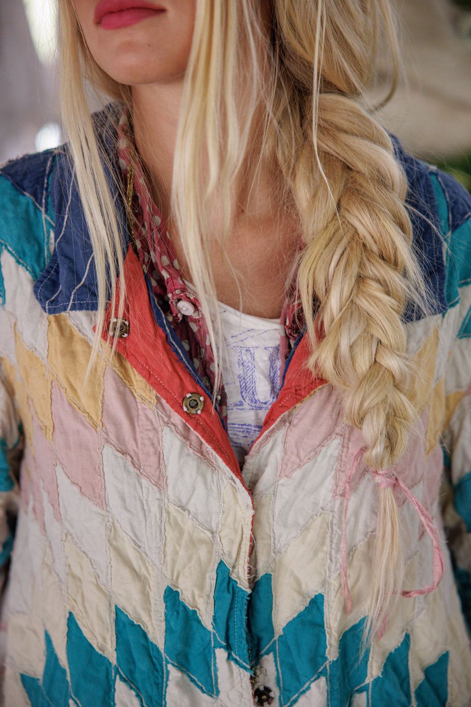 Woman in a colorful patchwork quilt jacket with a loose blonde side braid