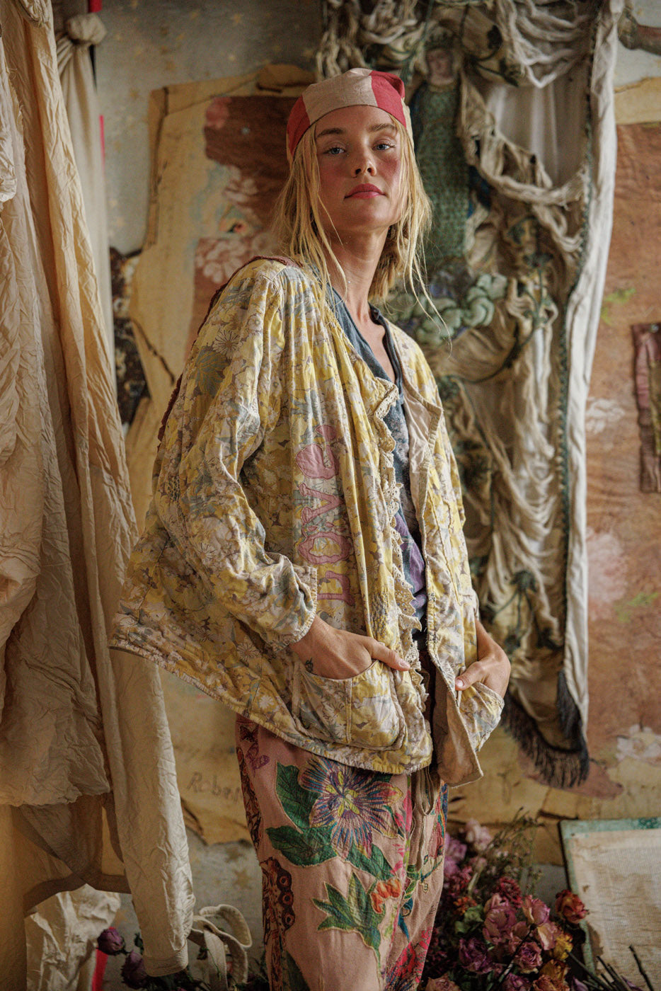 Woman in Magnolia Pearl artisan floral jacket and whimsical vintage pants in boho setting