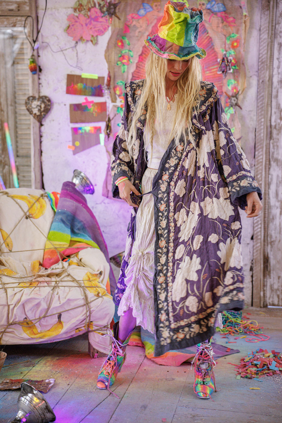 Magnolia Pearl model in boho floral embroidered jacket, rainbow hat, and vintage-themed artistic studio