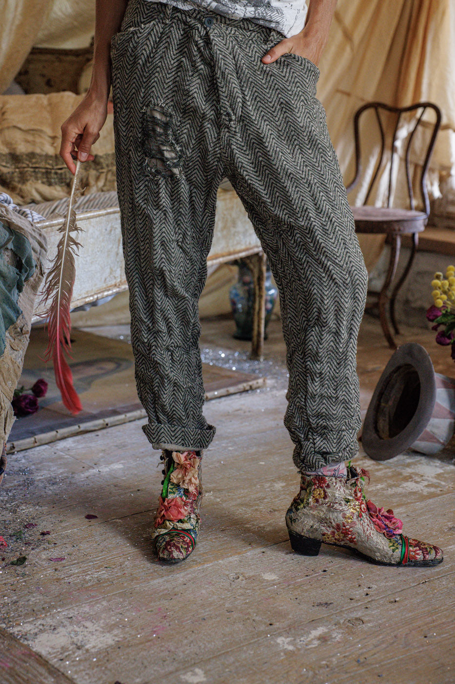 Herringbone patterned pants with ripped detail and floral boots in vintage room setting