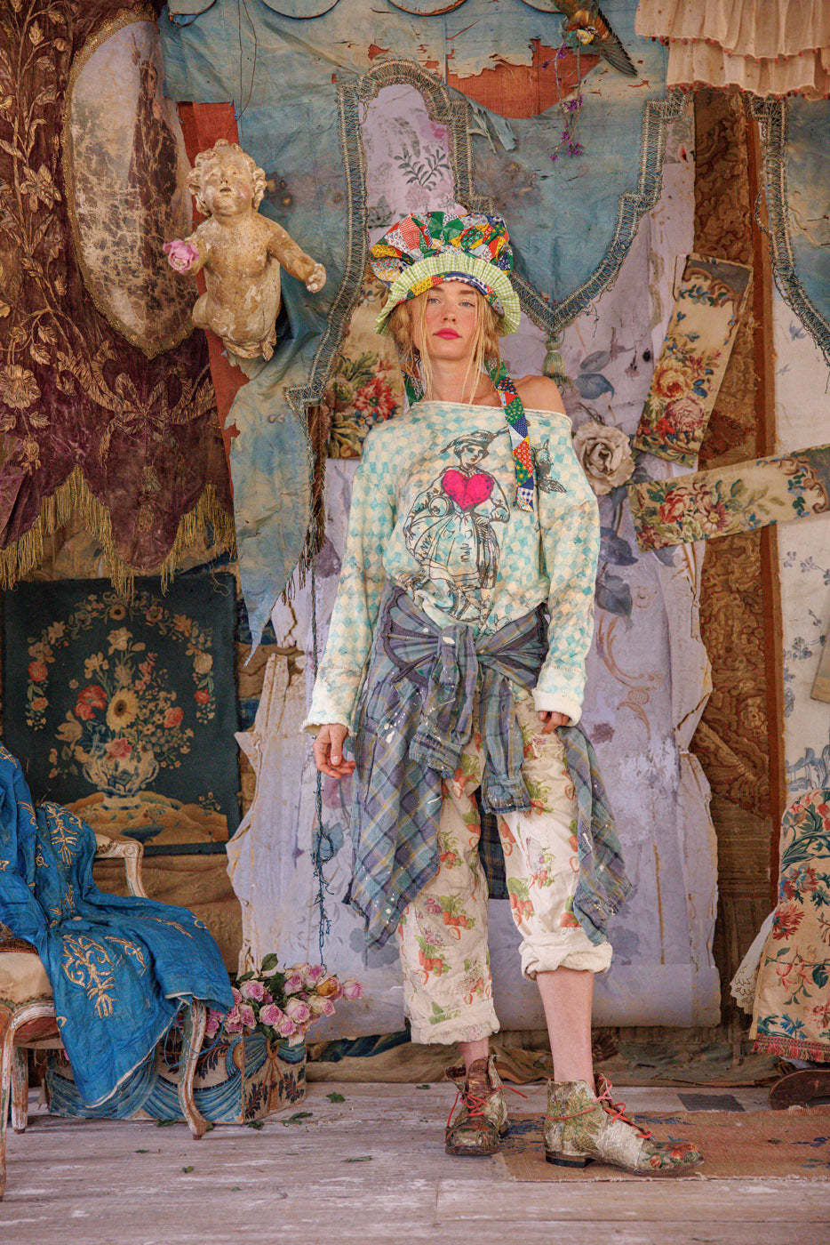 Woman in Magnolia Pearl artisan vintage floral pants, whimsical patchwork hat, eclectic boho style