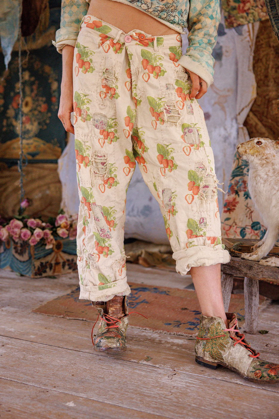 Woman in Magnolia Pearl artisan vintage floral pants, whimsical patchwork hat, eclectic boho style