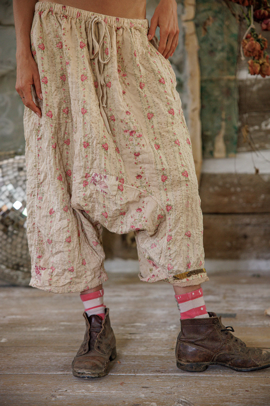 Magnolia Pearl artisan floral patchwork pants, whimsical vintage style, rustic boots, wooden floor