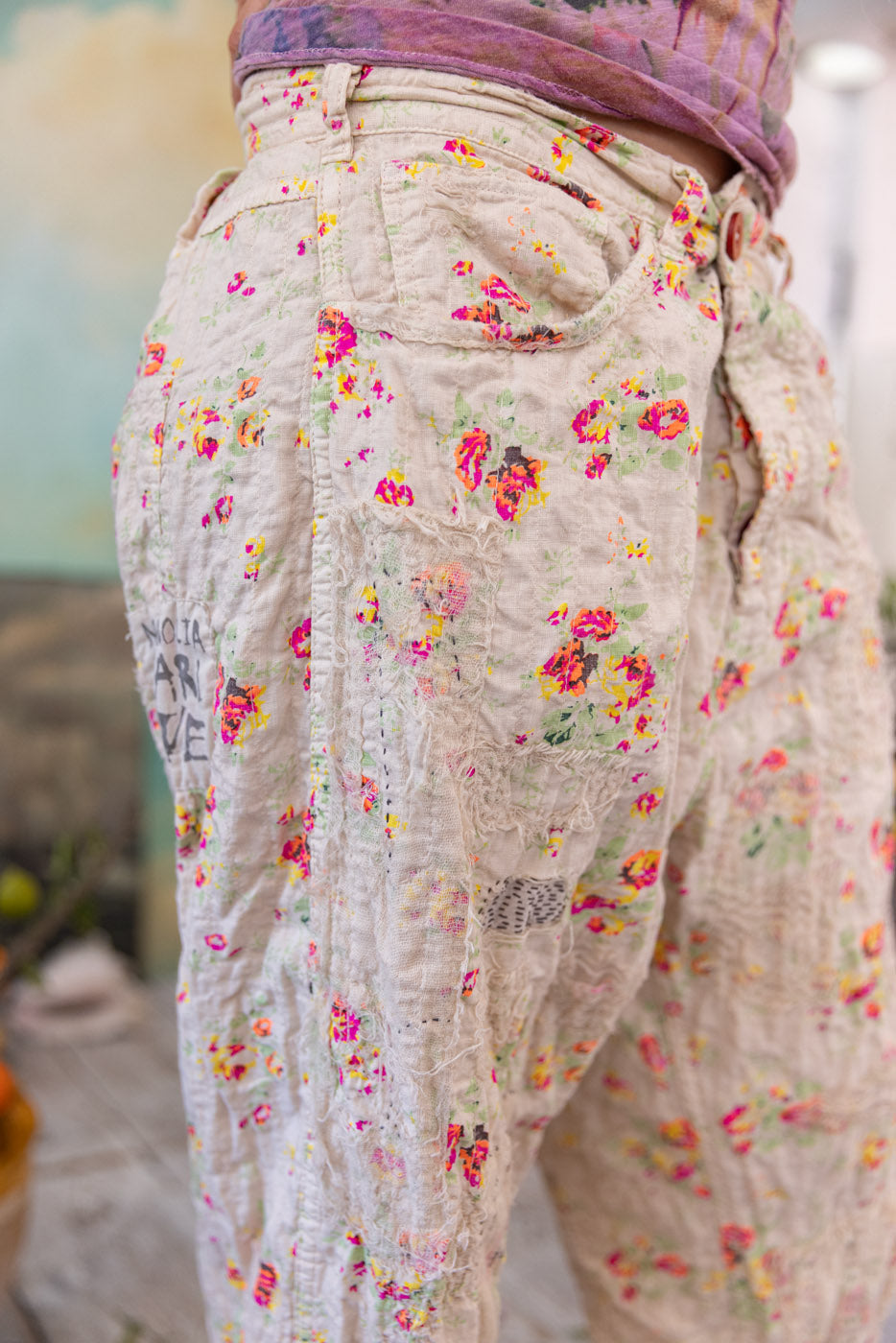 Magnolia Pearl artisan floral vintage patchwork pants, whimsical design, rustic setting
