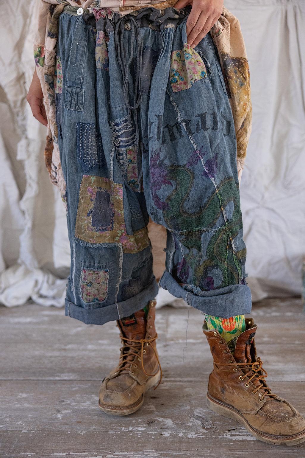 Magnolia Pearl artisan patchwork denim pants with vintage style, whimsical dragon and floral designs, rustic boots