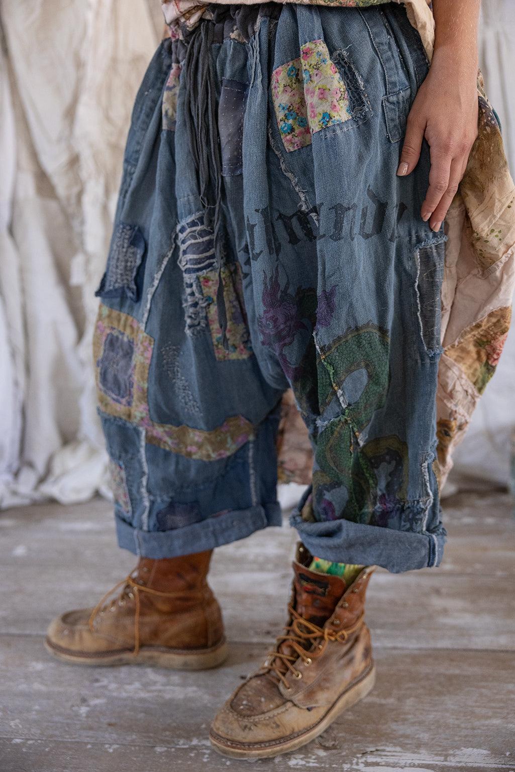 Magnolia Pearl artisan patchwork denim pants with vintage style, whimsical dragon and floral designs, rustic boots