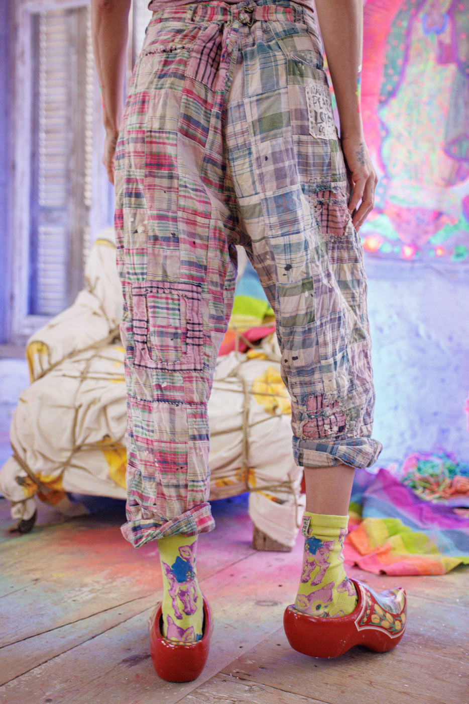 Magnolia Pearl artisan patchwork pants with whimsical design, vintage style, colorful background