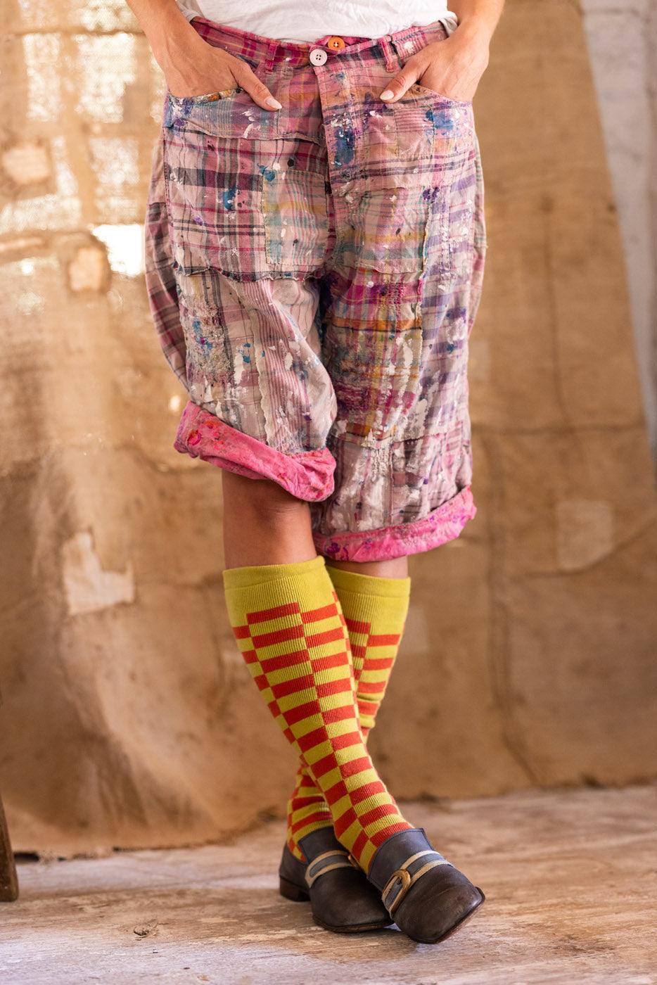 Woman in Magnolia Pearl vintage patchwork shorts, whimsical artisan clothing, rustic room