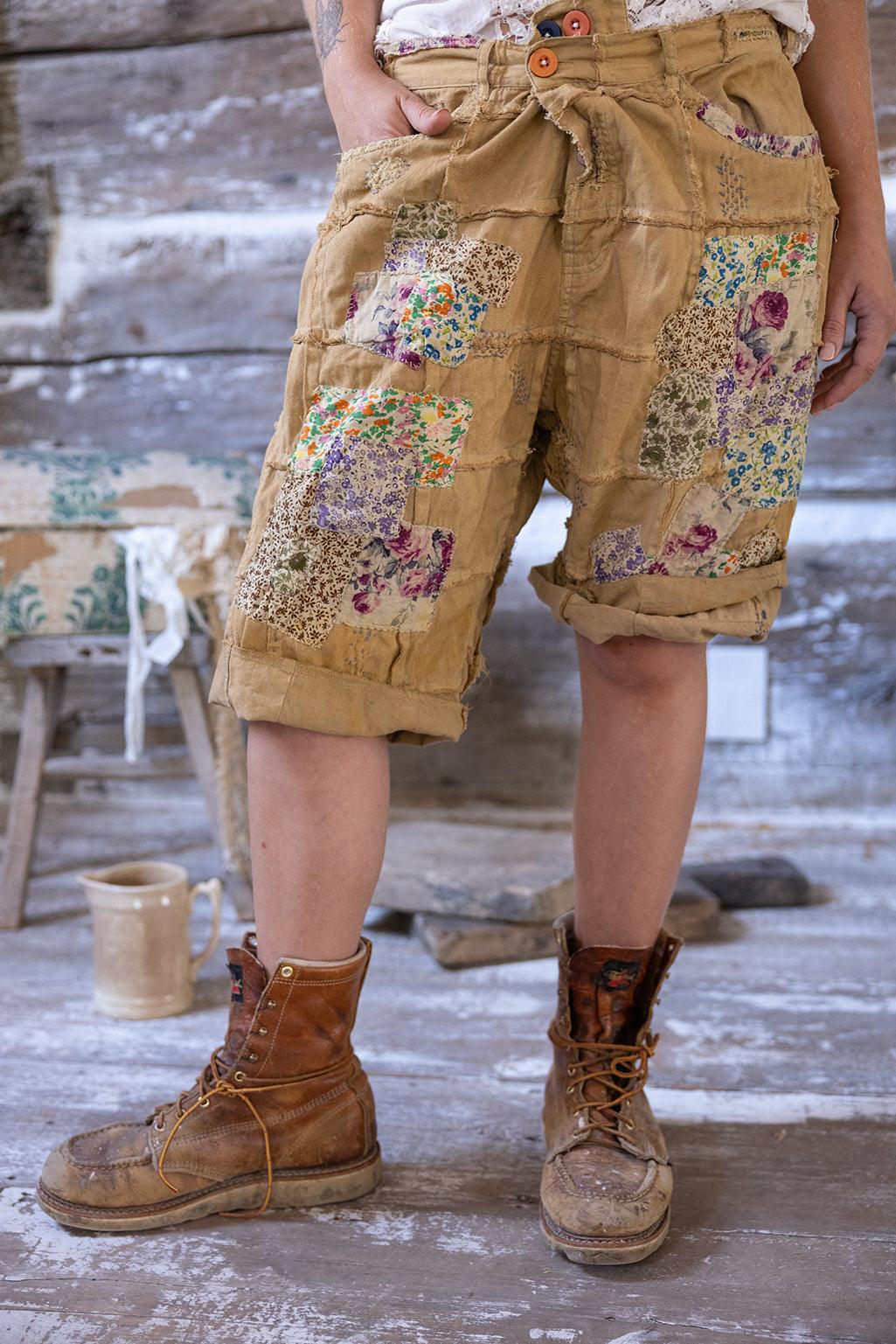 Woman in Magnolia Pearl artisan clothing with whimsical patched shorts, floral boots, vintage hat