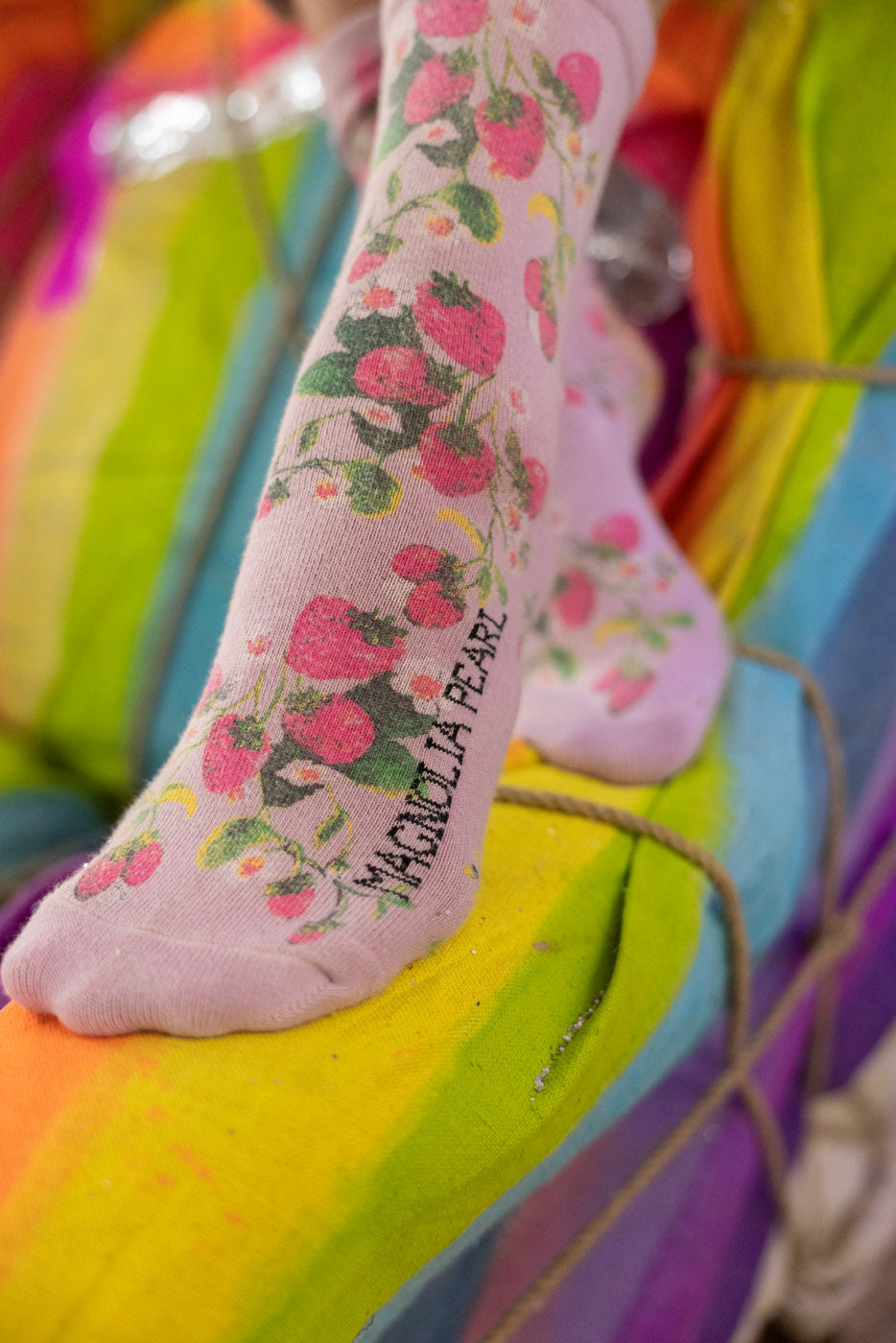 strawberry-patterned socks on a colorful background