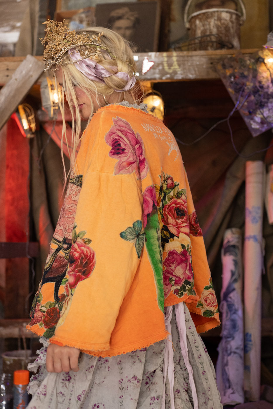 Person wearing a floral-patterned orange crew neck sweatshirt with a blurred background