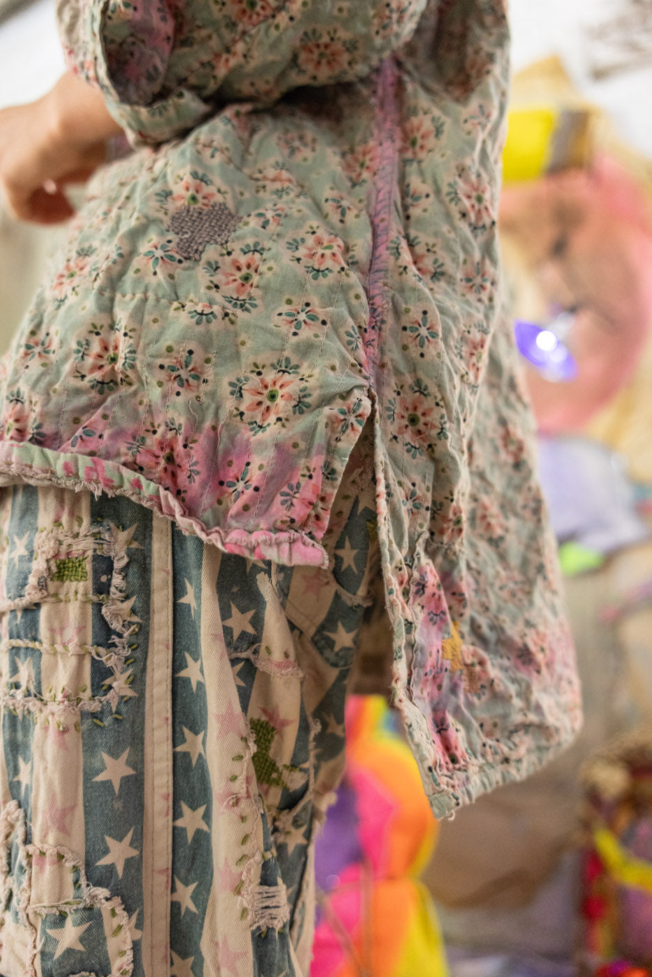 Person wearing a floral button down with a colorful background