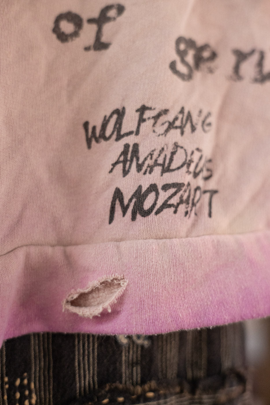 Pink jacket with text 'Wolfgang Amadeus Mozart' and a tear on the trim.