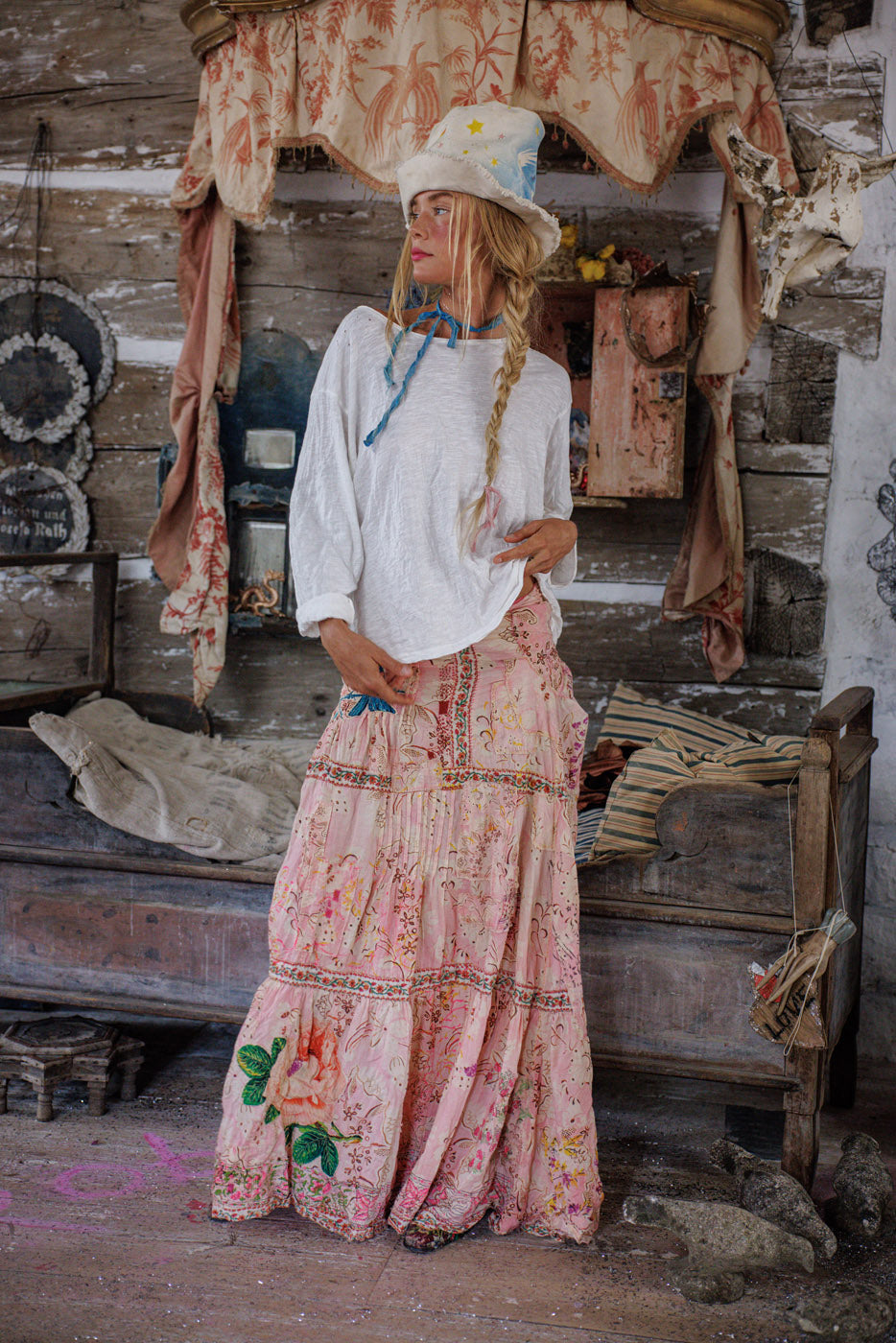 Woman in Magnolia Pearl artisan vintage-style floral maxi skirt and whimsical star hat