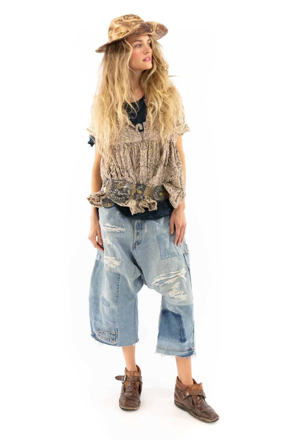 Woman in Magnolia Pearl artisan vintage clothing, patchwork jeans, ruffled vest, and hat