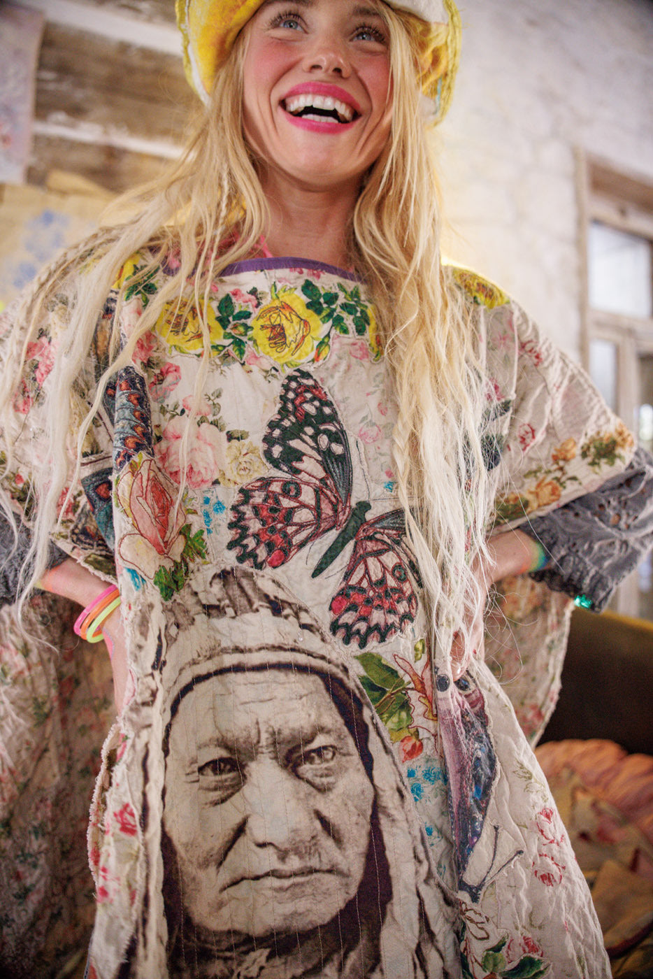 Smiling woman in Magnolia Pearl artisan vintage dress with floral, butterfly, and portrait print