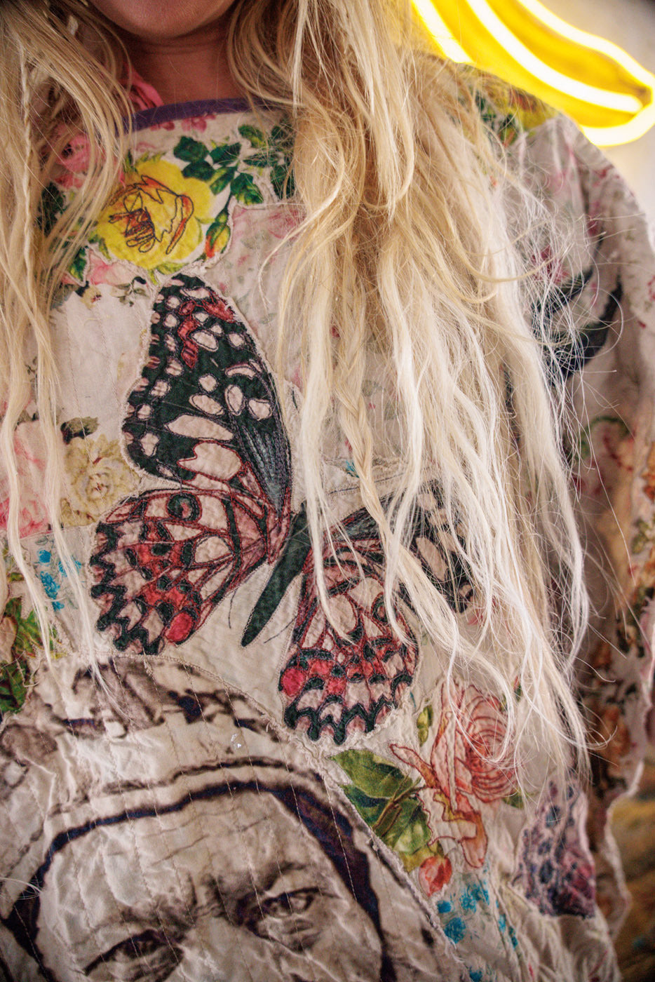 Magnolia Pearl artisan top with whimsical butterfly and floral vintage designs, blonde hair detail