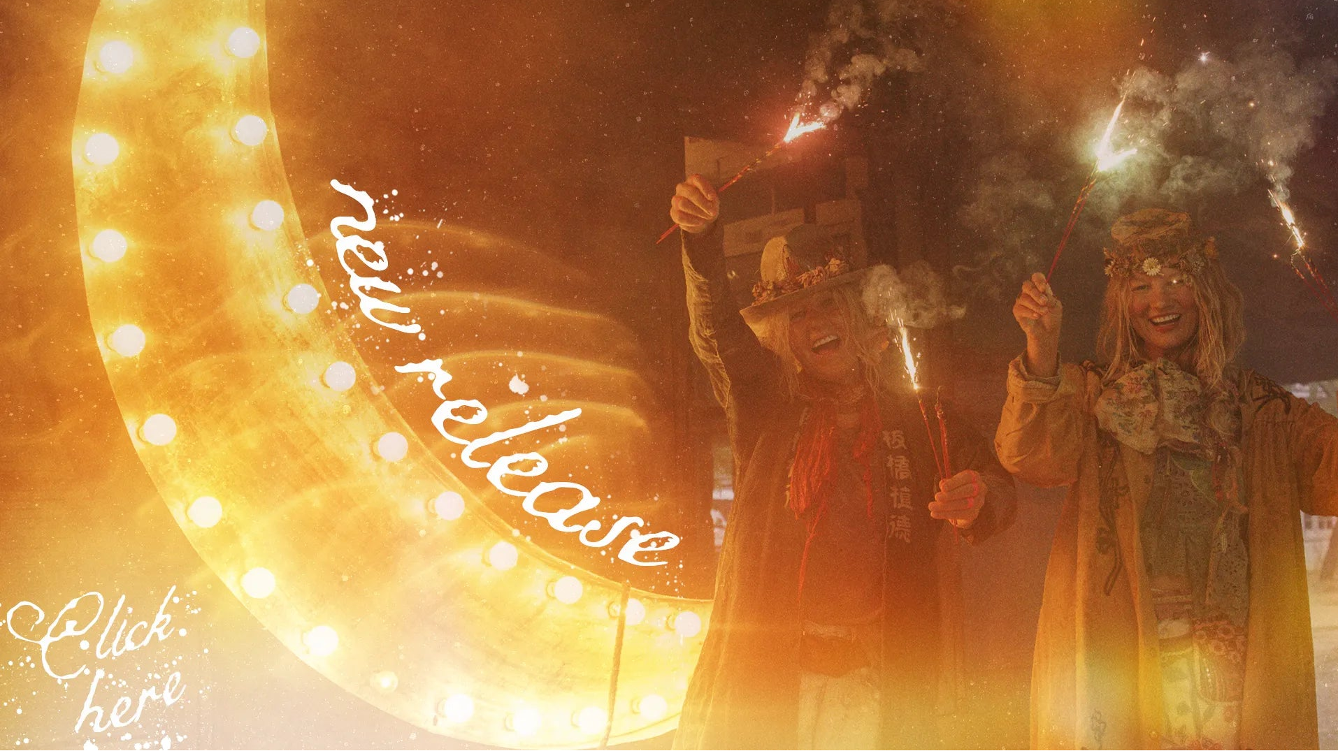 A festive scene with two people standing in front of a large glowing marquee light at night, holding sparklers or fireworks. The image has warm golden-orange lighting, smoke, and decorative text reading 'new release' and 'Click here'.