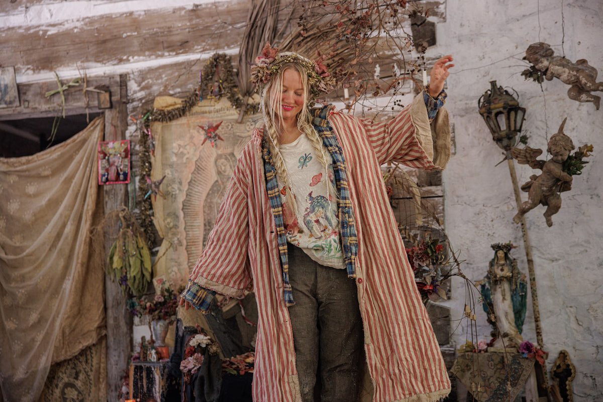 Woman in Magnolia Pearl artisan striped coat and whimsical vintage clothing, boho studio setting