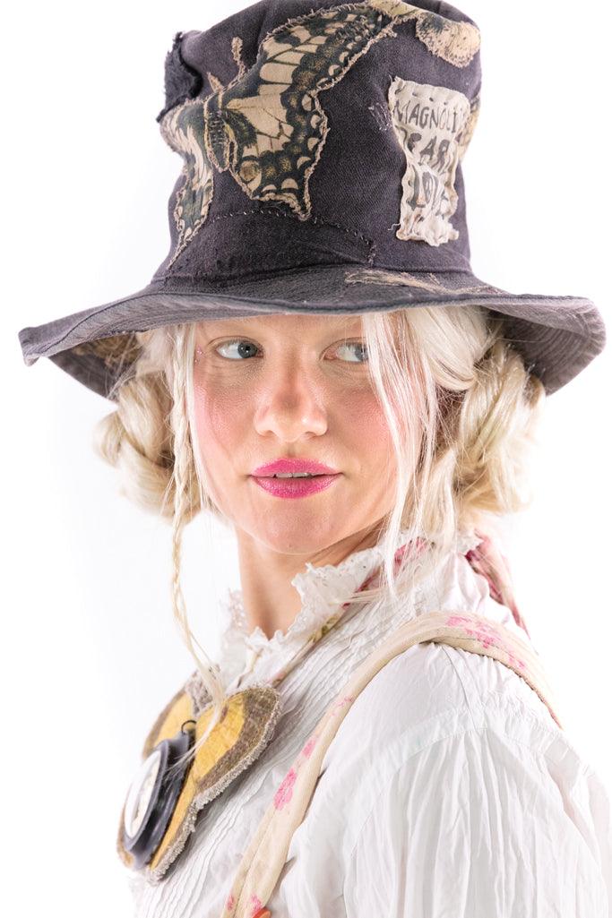 Woman in Magnolia Pearl artisan hat with whimsical butterfly patch, vintage style blouse