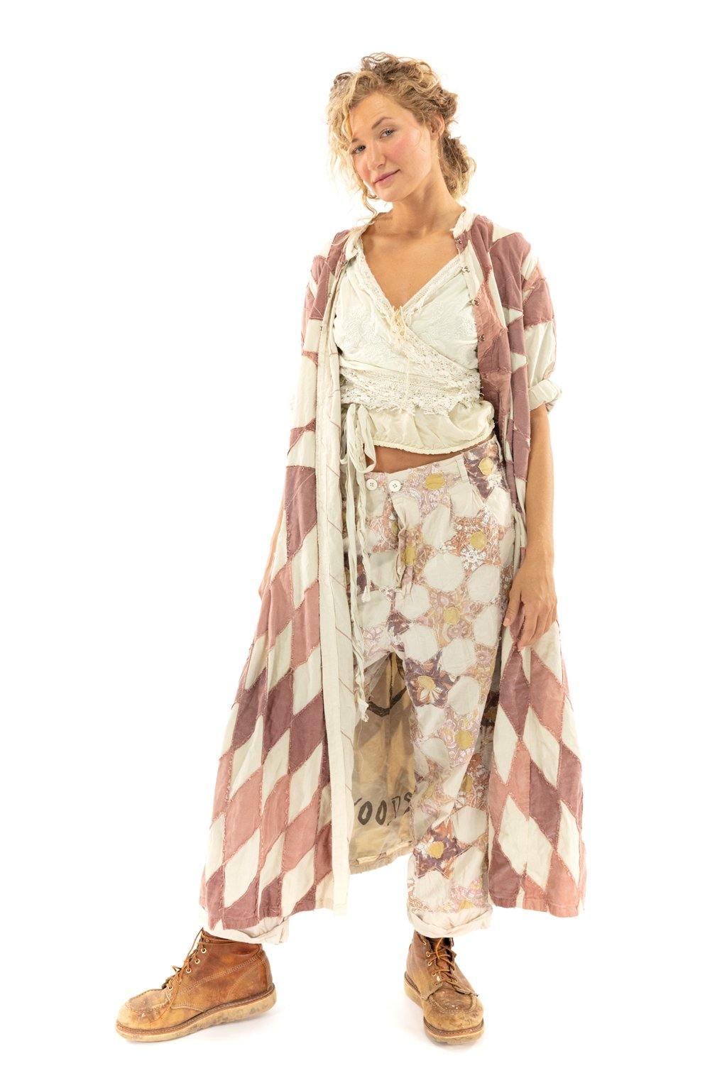 Woman in Magnolia Pearl artisan vintage duster jacket, whimsical patchwork outfit, and boots