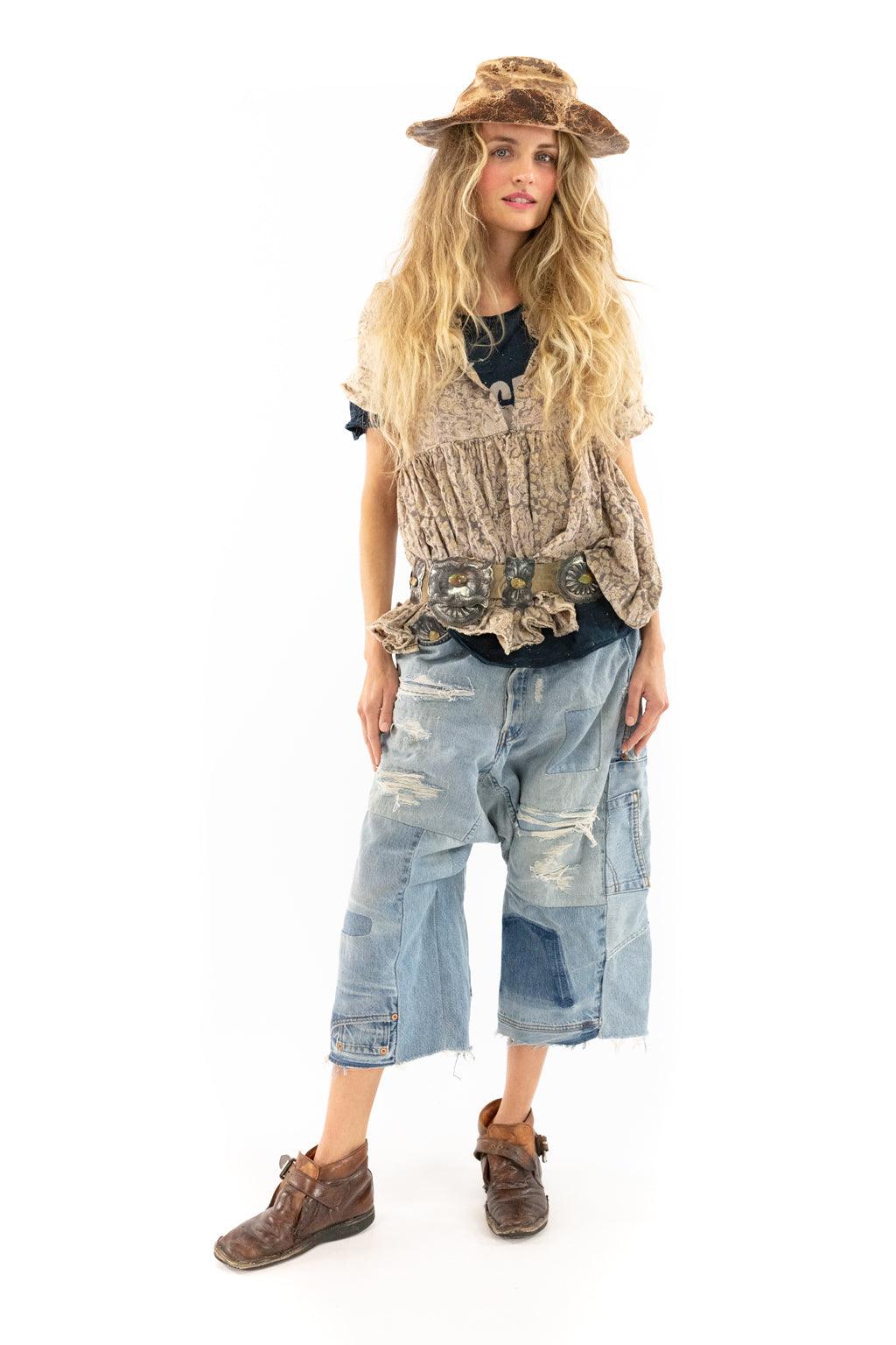 Woman in Magnolia Pearl artisan vintage clothing, patchwork jeans, ruffled vest, and hat